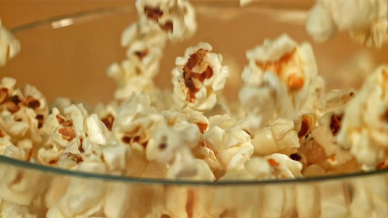 Popcorn al rallentatore che cade in una ciotola di vetro