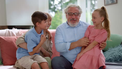 abuelo y abuela felices hablando con los nietos en casa