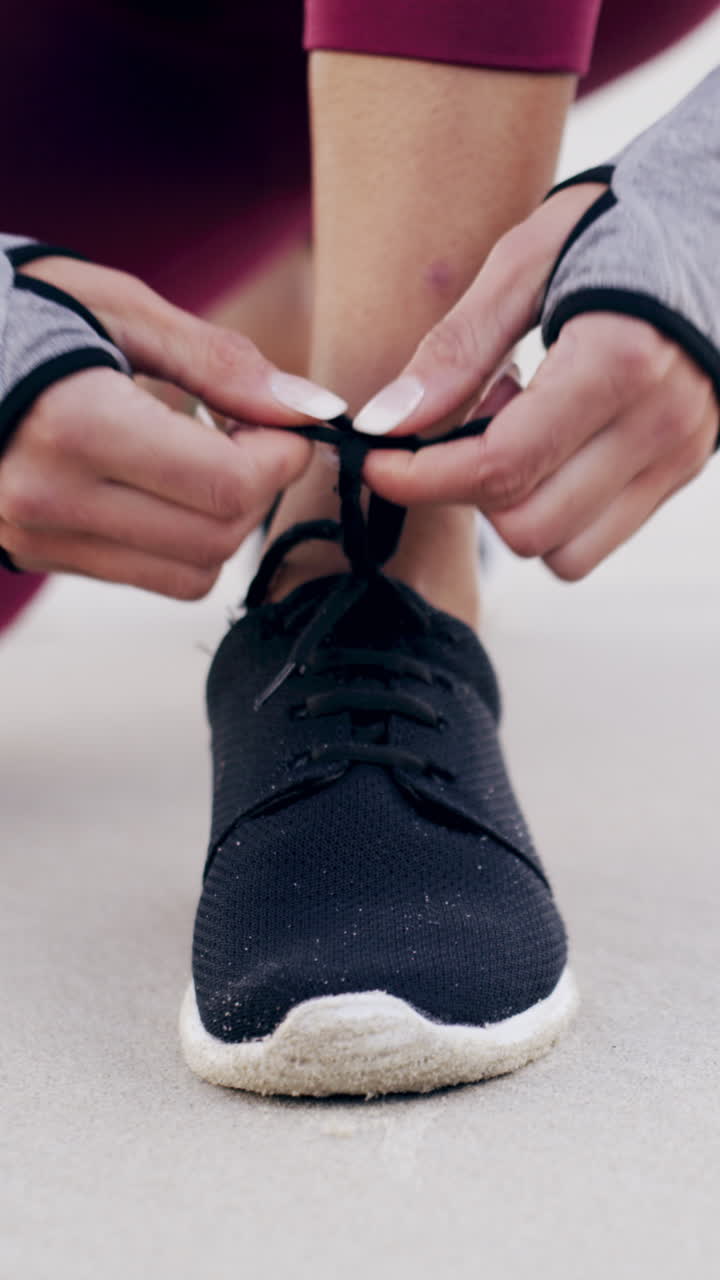 Primo piano di una donna che si allaccia le stringhe delle scarpe da corsa all'aperto