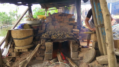 potter arranges clay animal figurine on firing kiln than ha vietnam, frontal view hoi an