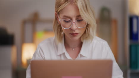 Nahaufnahme-Einer-Frau-Mit-Brille,-Die-Abends-Am-Laptop-Arbeitet