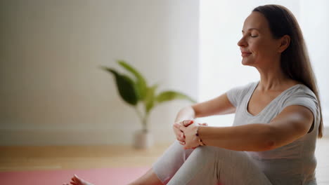 woman meditating or practicing yoga indoors