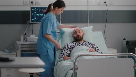 asistente del médico que arregla la cama del paciente para el enfermo durante la recuperación de la enfermedad