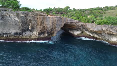 aerial shot of broken beach with cliffs and the sea below