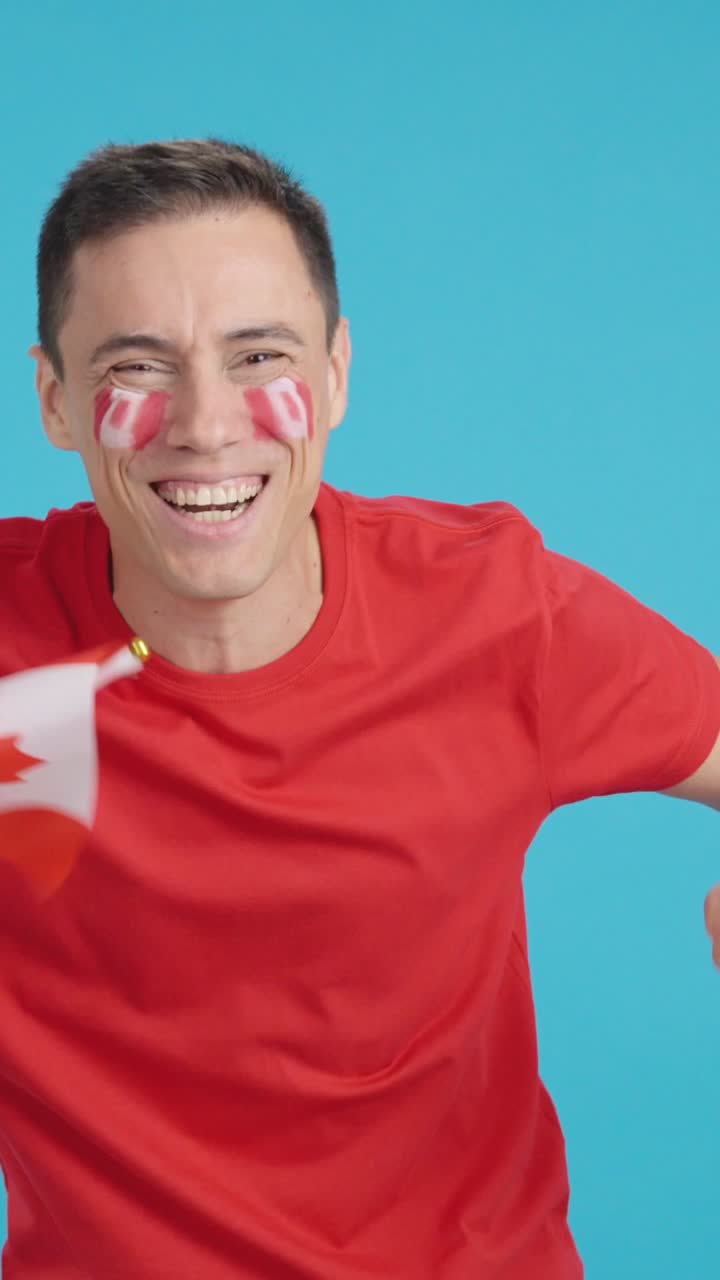Man cheering for Canada screaming and waving a national flag
