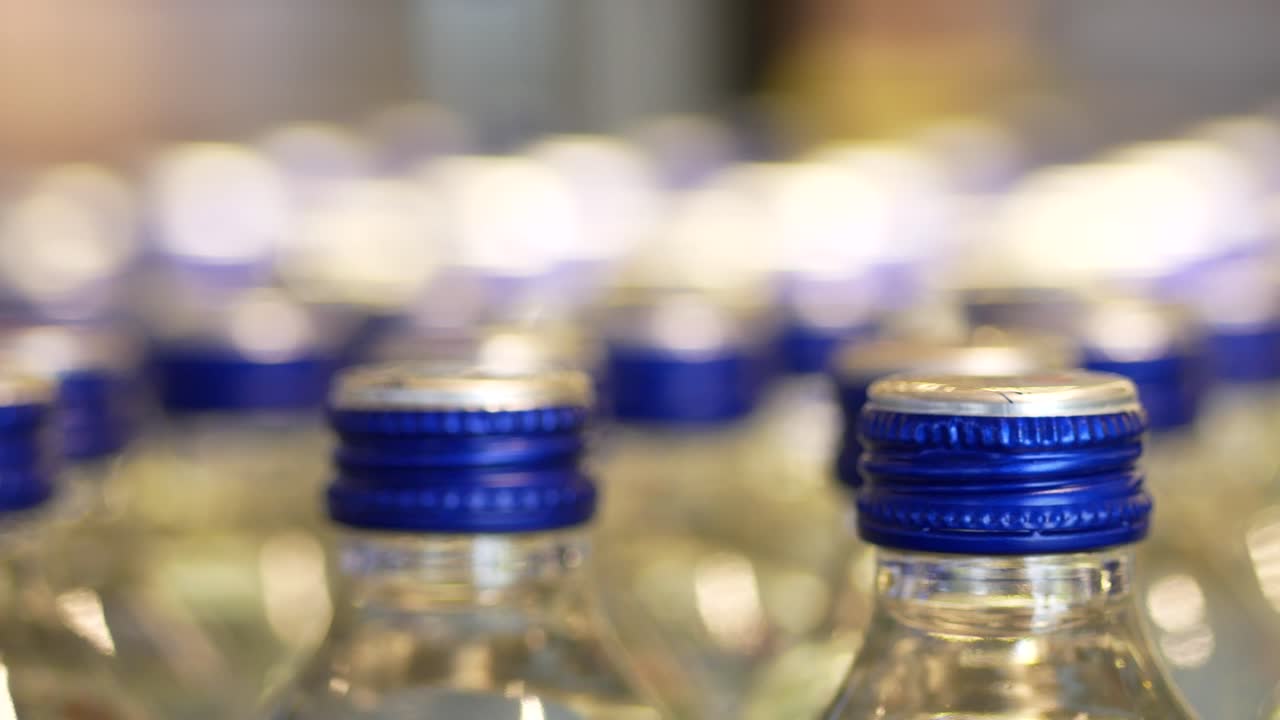 primer plano de muchas botellas de agua con tapas azules