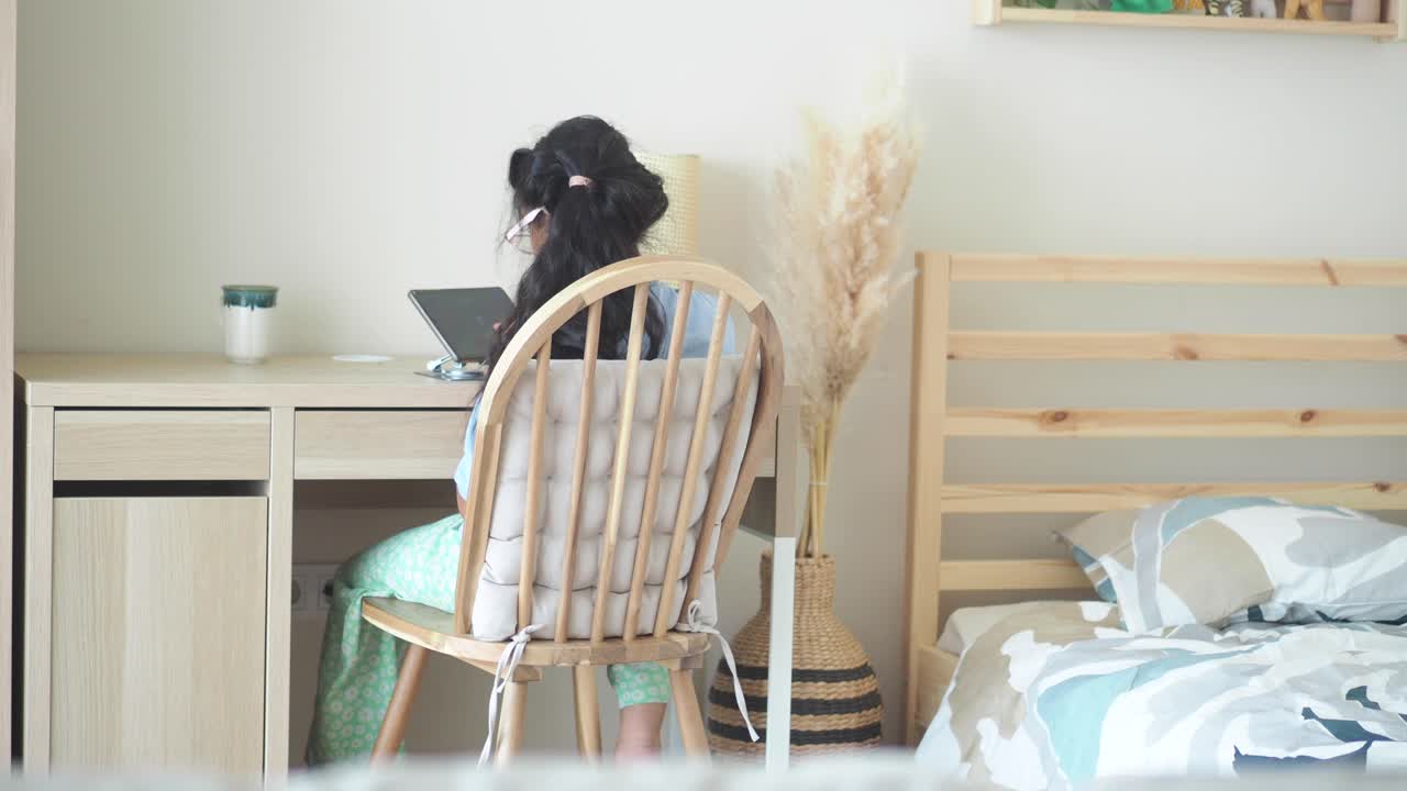 Girl working on a computer in her bedroom