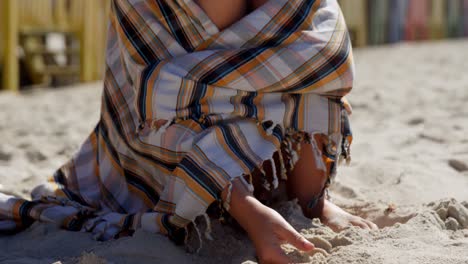 Teenager-Mädchen,-Eingewickelt-In-Eine-Decke,-Spielt-Mit-Sand-4k