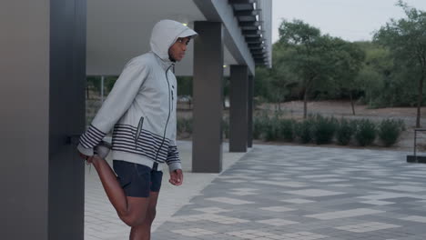 joven negro estirando las piernas antes de correr al aire libre 1