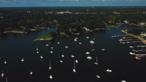 Drone-flying-from-harbor-inland-over-yachts-and-fancy-mansions-on-a-summer-day-in-the-northeast-in-4K