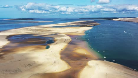 banc d'arguin in arcachon bassin france with boats anchored in a row along the edge, aerial dolly right reveal shot