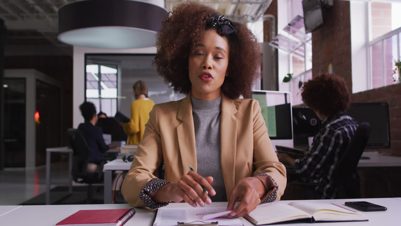 Femme d'affaires métisse heureuse en visioconférence assise devant un ordinateur