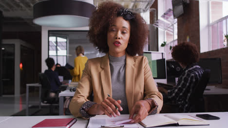 Happy-mixed-race-businesswoman-having-video-call-sitting-in-front-of-computer