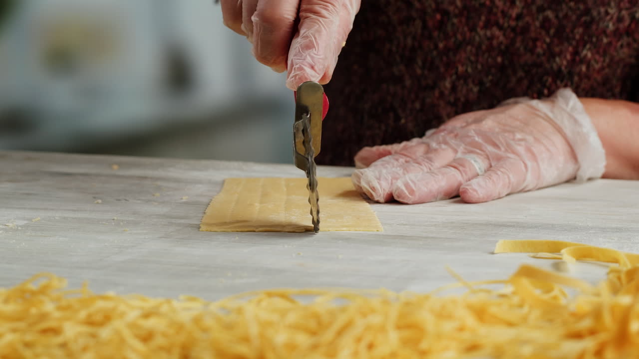 Close-up of Hands in Gloves Cutting Fresh Pasta Dough