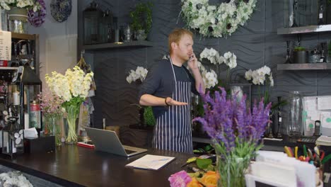 Man-talking-phone-while-working-in-shop