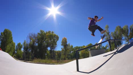 skateboarder grinds the rail on a sunny colorado afternoon