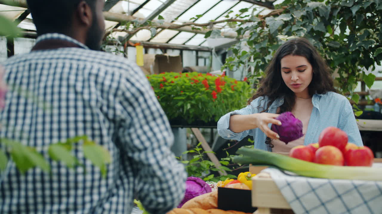 People Shopping for Fresh Produce at a Greenhouse Market