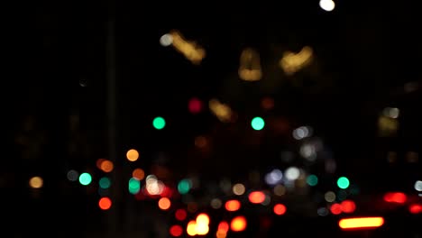 Cars-and-traffic-lights-bokeh-in-black-night-background,-colorful-lights-in-yellow,-green,-orange-and-red-flash,-abstract-background