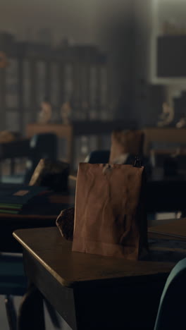 empty classroom desk with lunch bag