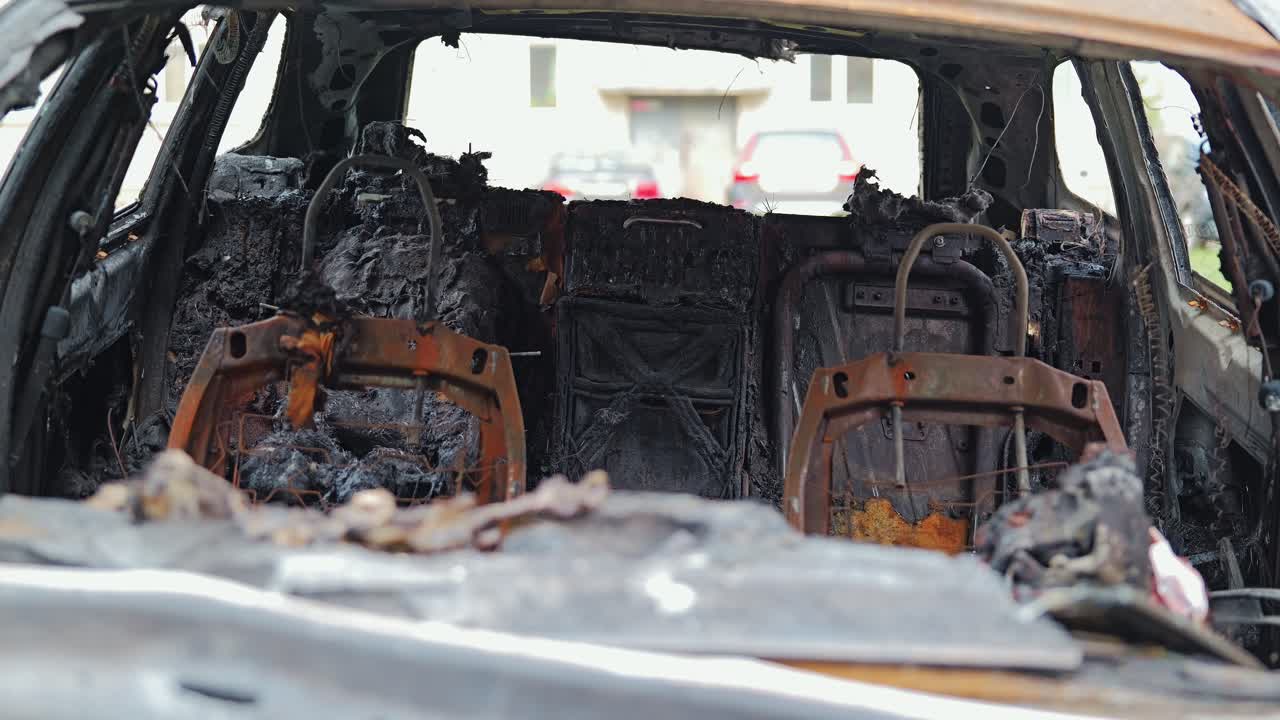 Charred seat frames and melted interior reveal aftermath of severe vehicle fire