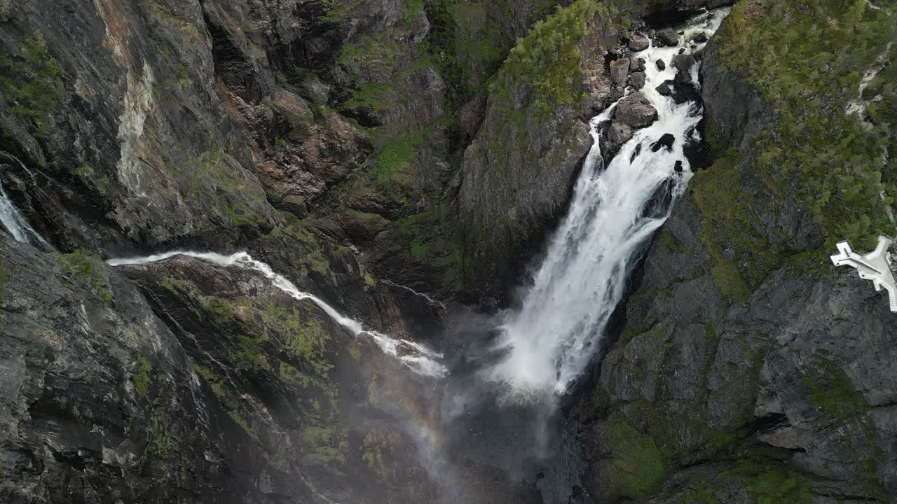 Impressive drone footage taken at Vøringsfossen waterfall in Norway, in Hardangervidda Park. The water cascades continuously into the deep gorge. Next to the waterfall is the steep rocky landscape