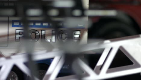 coche de policía en la escena del crimen, vista a través de la toma panorámica de la cerca