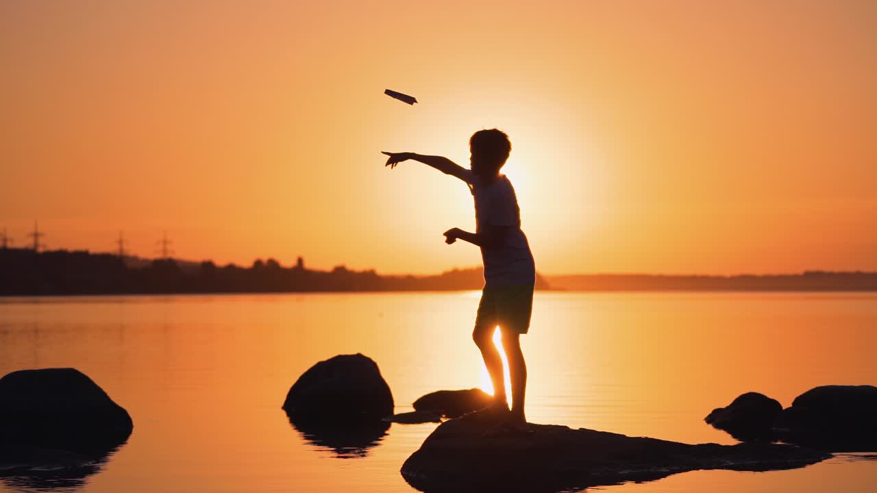 A happy child is playing with a paper airplane at sunset. Classes with children outdoors. Lifestyle