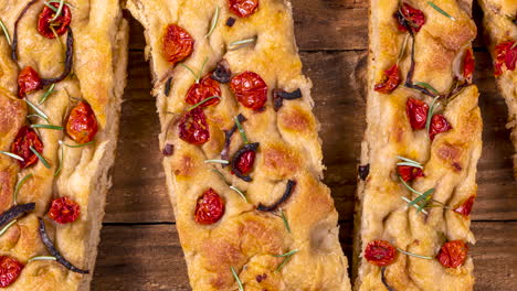 Traditional-Italian-Focaccia-with-pepperoni,-cherry-tomatoes,-black-olives,-rosemary-ando-onion---homemade-flat-bread-focaccia