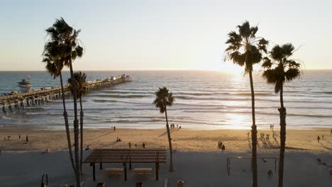 Playground-and-beach-at-sunset-in-San-Clemente-Pier-Beach,-California,-aerial-wide-static-shot