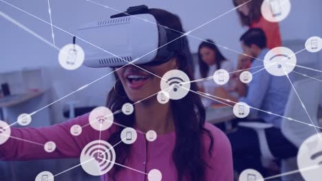 Animation-of-network-of-connections-with-icons-over-diverse-business-people-using-vr-headset