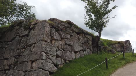 Toma-Panorámica-Lenta-De-Las-Ruinas-De-Un-Muro-De-Piedra-Adoquinada-En-El-Impresionante-Castillo-De-Takeda