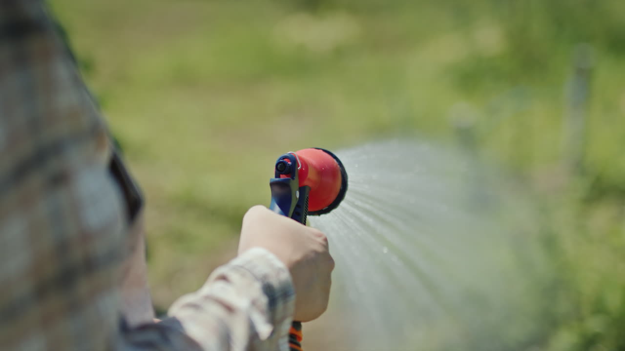 jardinero rocía agua de una manguera de jardín 1