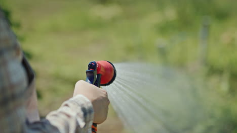 jardinero rocía agua de una manguera de jardín 1