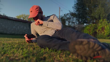 enjoying screen time, a young man outdoors on his phone