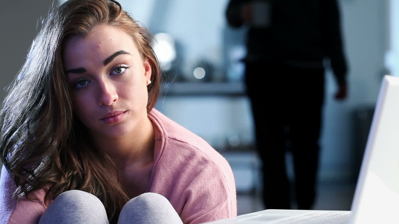 Sad depressed teenage girl using laptop