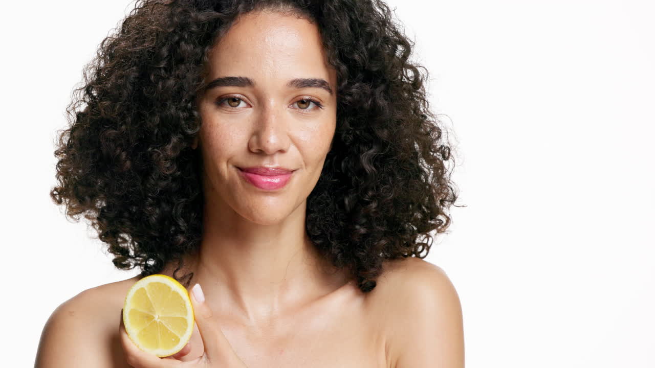 Donna con i capelli ricci che tiene in mano un limone