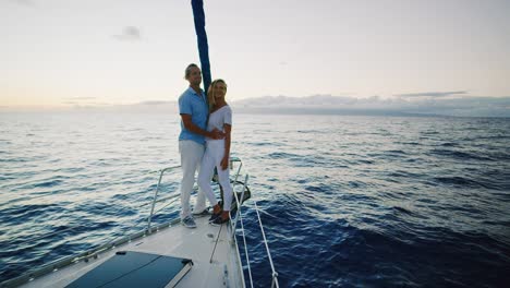 pareja navegando en yate al atardecer