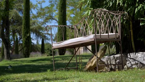 slow establishing shot of metal garden chair with a cushion outside a villa