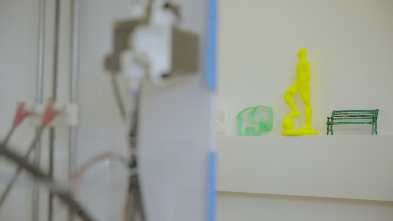 close up shot 3d printer moving parts axis wires daylight. Ready made printed product in the background.