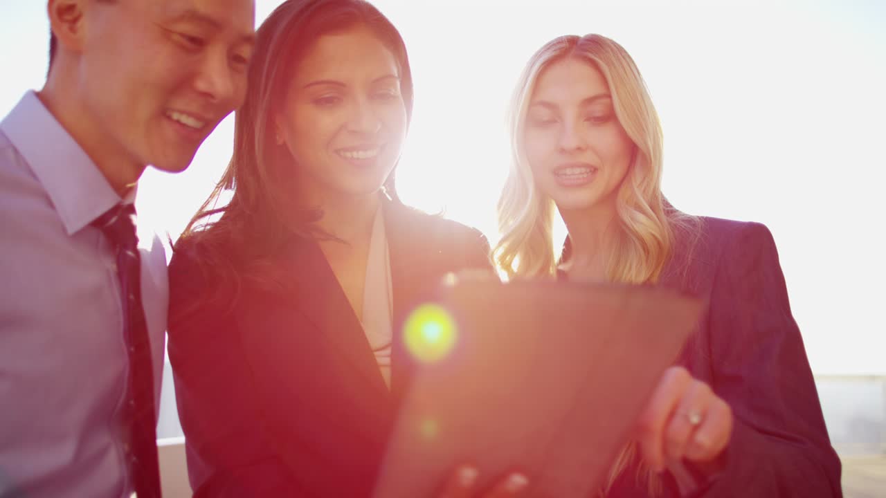 다민족 사업가 들 이 지붕 에 터치 스크린 을 사용 하고 있다