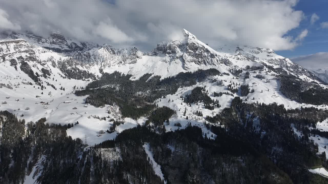 Vista cinematografica delle montagne innevate del Glarona con nuvole in Svizzera.