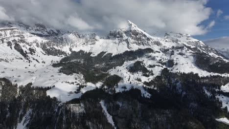vista cinematográfica de las montañas nevadas de glarus con nubes en suiza
