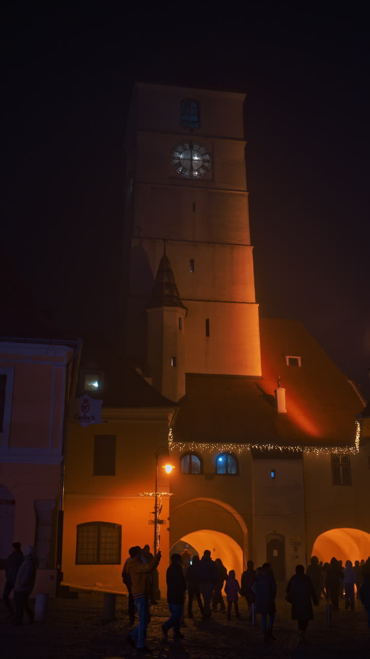 The Council Tower illuminated in the evening between the two main squares of the Historic center in Sibiu, Romania. Vertical