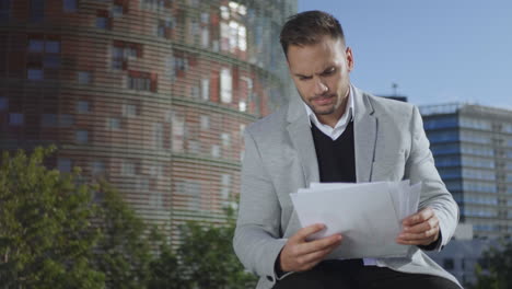 hombre de negocios leyendo documentos en la calle. ejecutivo trabajando con papeles al aire libre