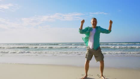 Front-view-of-active-senior-Caucasian-man-jumping-on-the-beach-4k