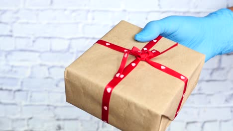 gift in a hand with blue medical gloves