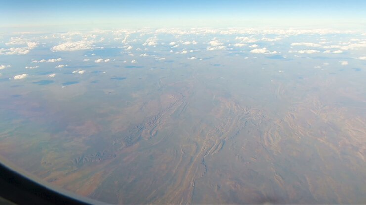White clouds casting shadows on red earth outback Australia Darwin to Sydney Northern Territory Australia