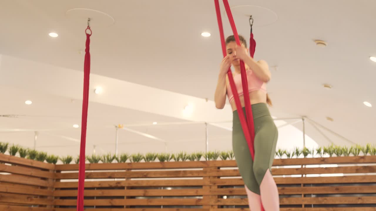 Young girl who wears tracksuit is in sporthall