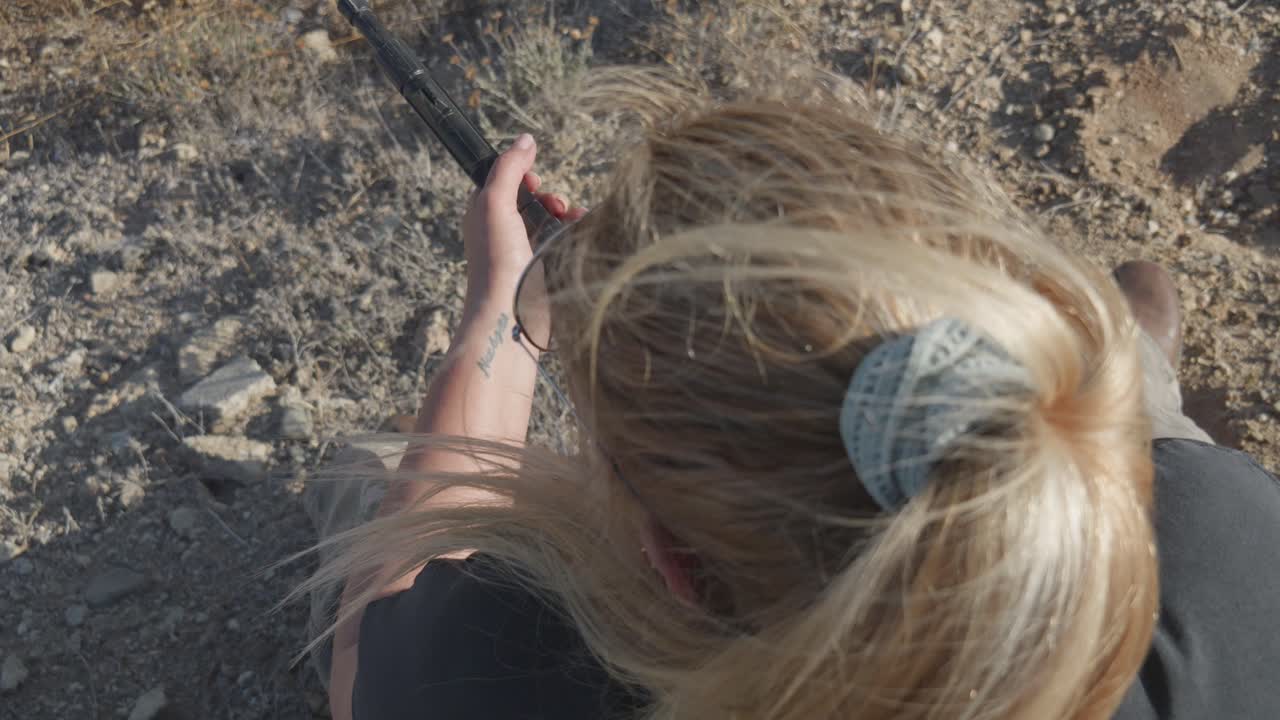 여자 전사 는 손 에 기관총 을 들고 앉아 전투 스테이션 에서 기다리고 있다