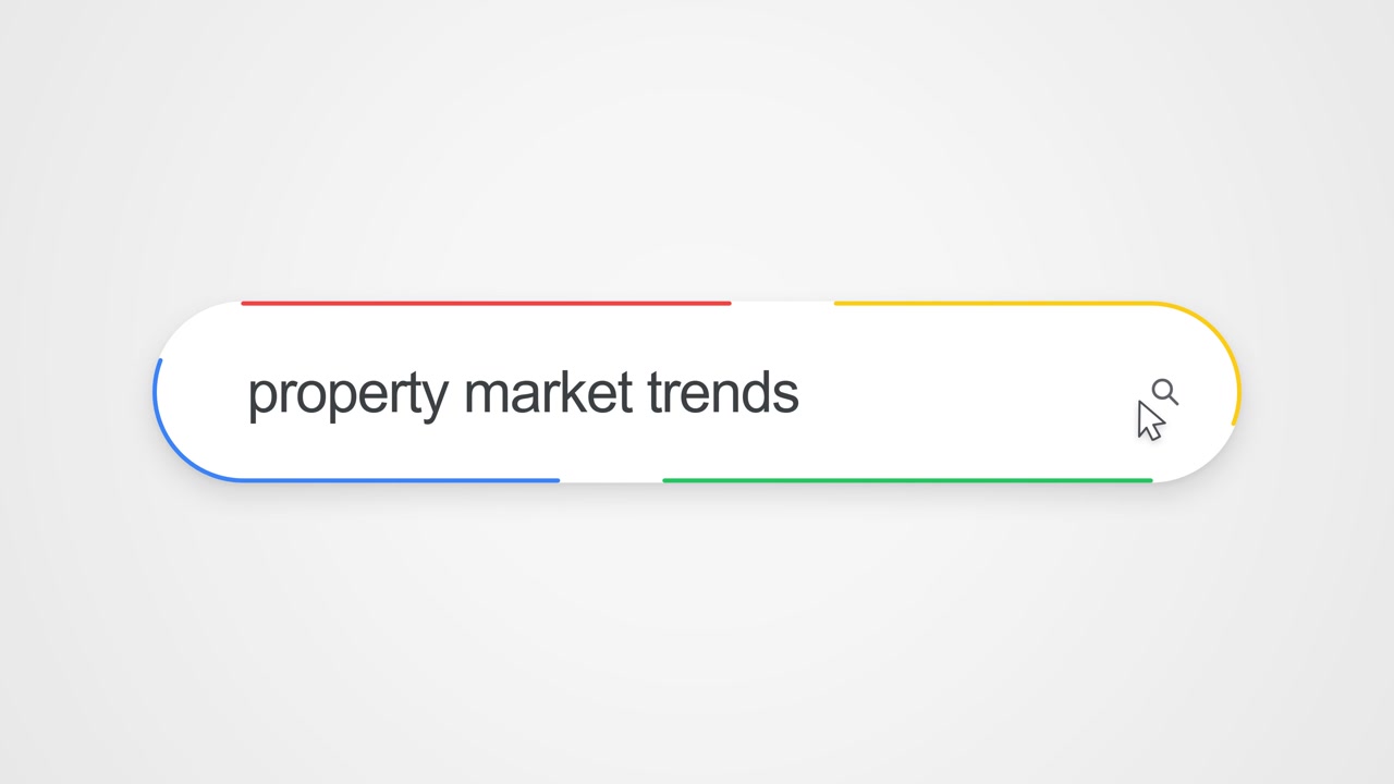 Close-up view of typing "property market trends" into an online search bar with a cursor clicking the search icon, illustrating internet search and real estate market research